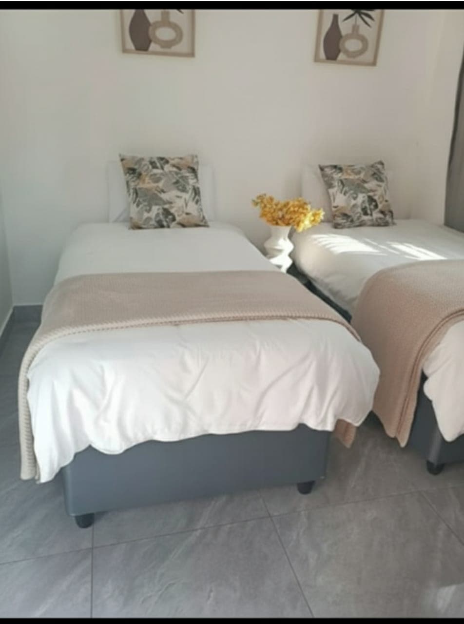 Standard twin room guesthouse Bellville South - clean twin beds with botanical pillows and modern ensuite bathroom