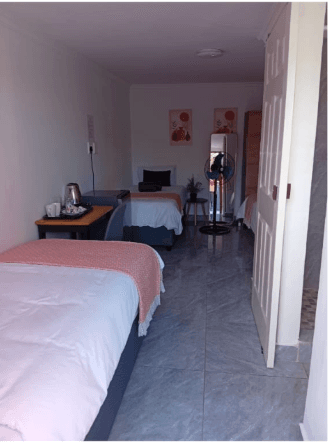 Triple room guesthouse Bellville South - spacious room with multiple beds, desk and tea station for contractor crews